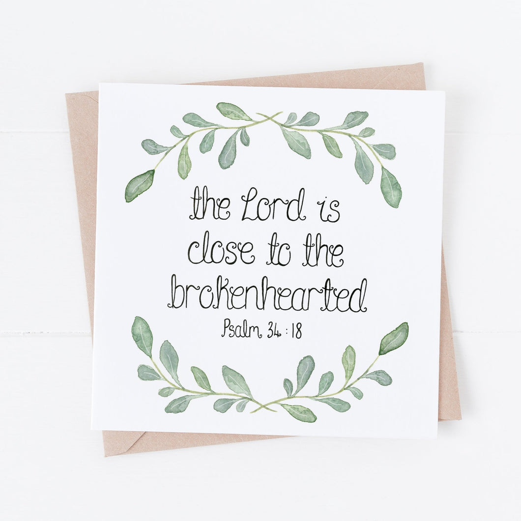A gentle card with the words, 'the Lord is close to the brokenhearted' from Psalm 34:18 with a simple watercolour leaf wreath design surrounding the words.