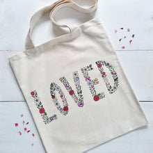 Load image into Gallery viewer, canvas tote bag with the word &#39;loved&#39; written with flowers, a stunning bag to spread the message that you are loved