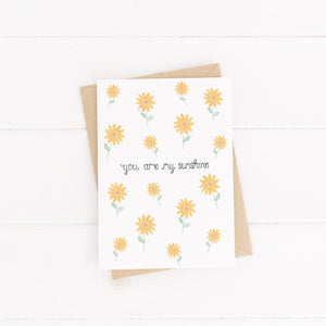 A joyful greeting card with a vibrant sunflower pattern and the words, you are my sunshine, lettered at the centre of the design. A bright and cheery greeting card to send a friend or loved one