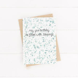 A green watercolour splattered unisex birthday card with the words, 'may your birthday be filled with blessings,' a sweet card to fill with celebration and loving words.