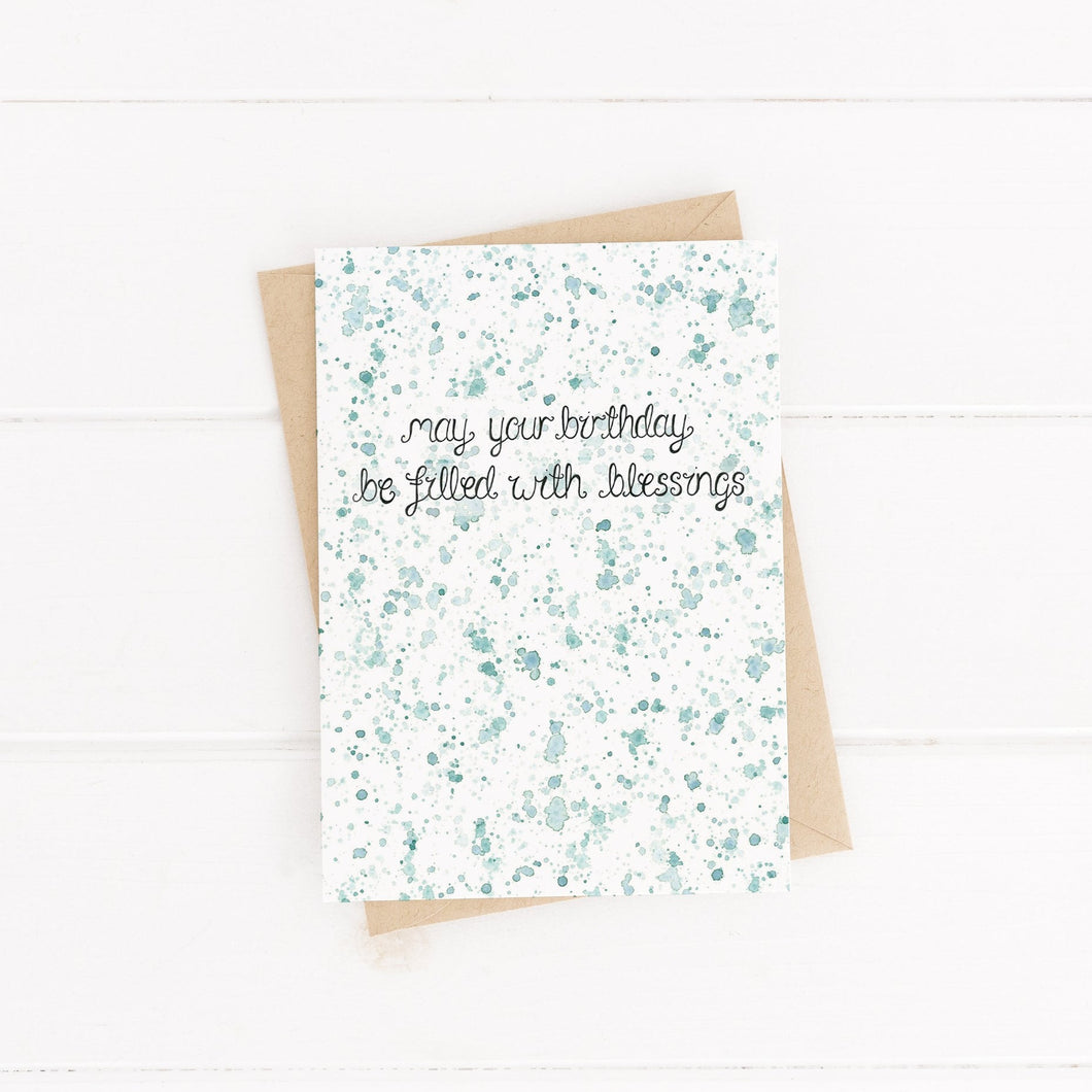 A green watercolour splattered unisex birthday card with the words, 'may your birthday be filled with blessings,' a sweet card to fill with celebration and loving words.