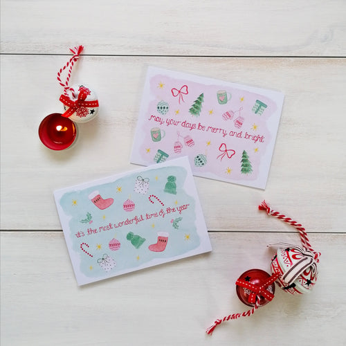 pink and green festive christmas cards with christmas songs lettered at the centre and christmas ornaments surrounding the words