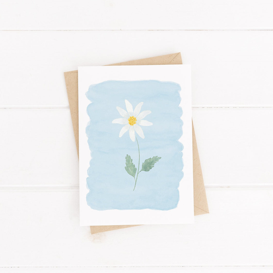 A sweet and simple greetings card, painted with a white daisy and blue watercolour background. A thoughtful design to send words of encouragement and friendship to a loved one.