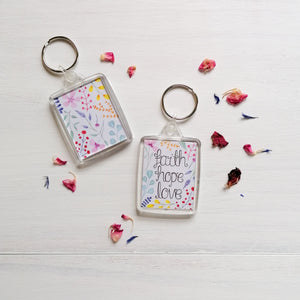 floral design keychain with the words faith hope and love hand lettered at the centre