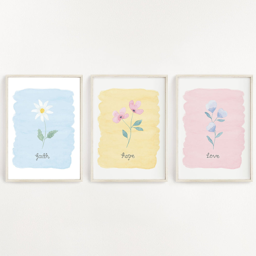 pretty wall print set of 3 designs with the words faith hope love written on each print with a dainty flower painted above the words with a pastel background colour. A stunning set of prints to have in the home.