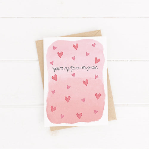 A sweet Valentines card with the words 'you're my favourite person' lettered onto a pink watercolour background surrounded by hearts. A fun greeting card to fill with loving words.