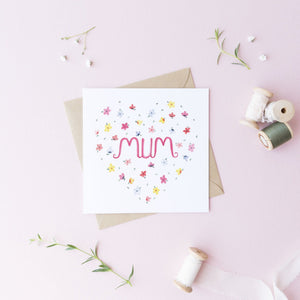 A pretty card for mums with the words mum painted in pink surrounded by flowers placed in a heart shape. The sweetest card for mothers day, fill with loving words and let mum know how much they mean to you.