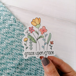floral vinyl sticker with the words grace upon grace hand lettered beneath