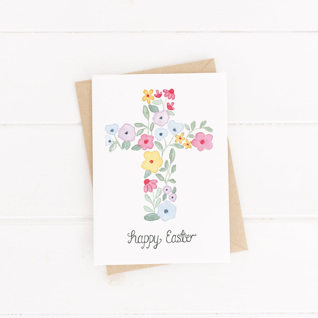 A sweet hand illustrated card with the words happy easter lettered beneath a watercolour cross shaped from flowers and leaves. A spring themed card to celebrate Easter with loved ones.