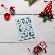Load image into Gallery viewer, christmas carol christmas card with the words, joy to the world, lettered at the centre with holly and berries surrounding