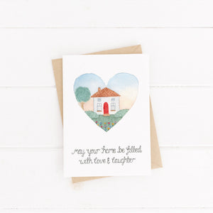 A stunning hand illustrated new home card with the words, 'may your home be filled with love and laughter' lettered beneath a watercolour house scene. A sweet card to send as a new home card.