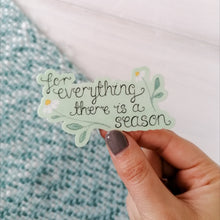 Load image into Gallery viewer, A stunning daisy sticker with the words, for everything there is a season hand lettered, with dainty daises surrounding the words on a pale green background.