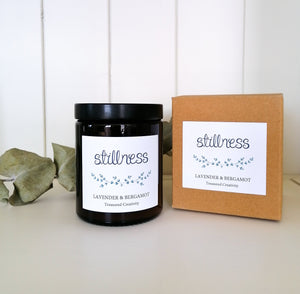 stillness soy candle with a lavender and bergamot scent with a kraft box