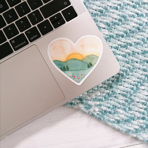 A stunning sunset landscape sticker hand painted into a heart shape. A dreamy design that would make a thoughtful gift to send a loved one as well as a joyful little treat to add to your laptop, water bottle or journal.