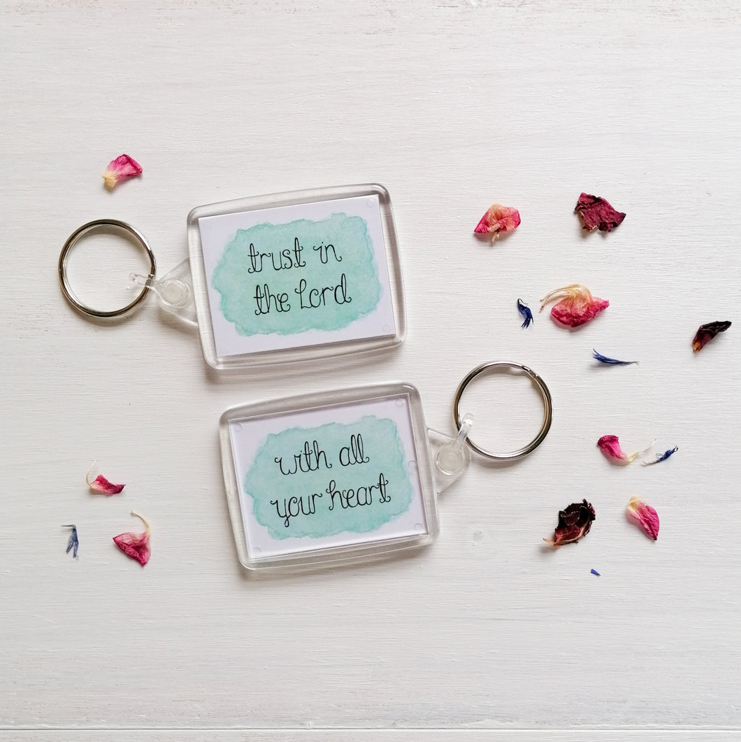 trust in the lord with all your heart bible verse keyring lettered on a blue watercolour background