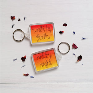walk by faith not by sight christian quote keychain lettered onto a watercolour sunset ombre background