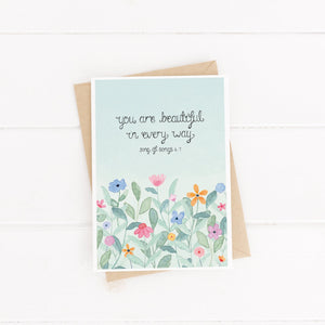 A Christian love card with the words, 'you are beautiful in every way' from Song of songs 4:7 lettered on a blue watercolour background with multicoloured flowers below the sweet words.